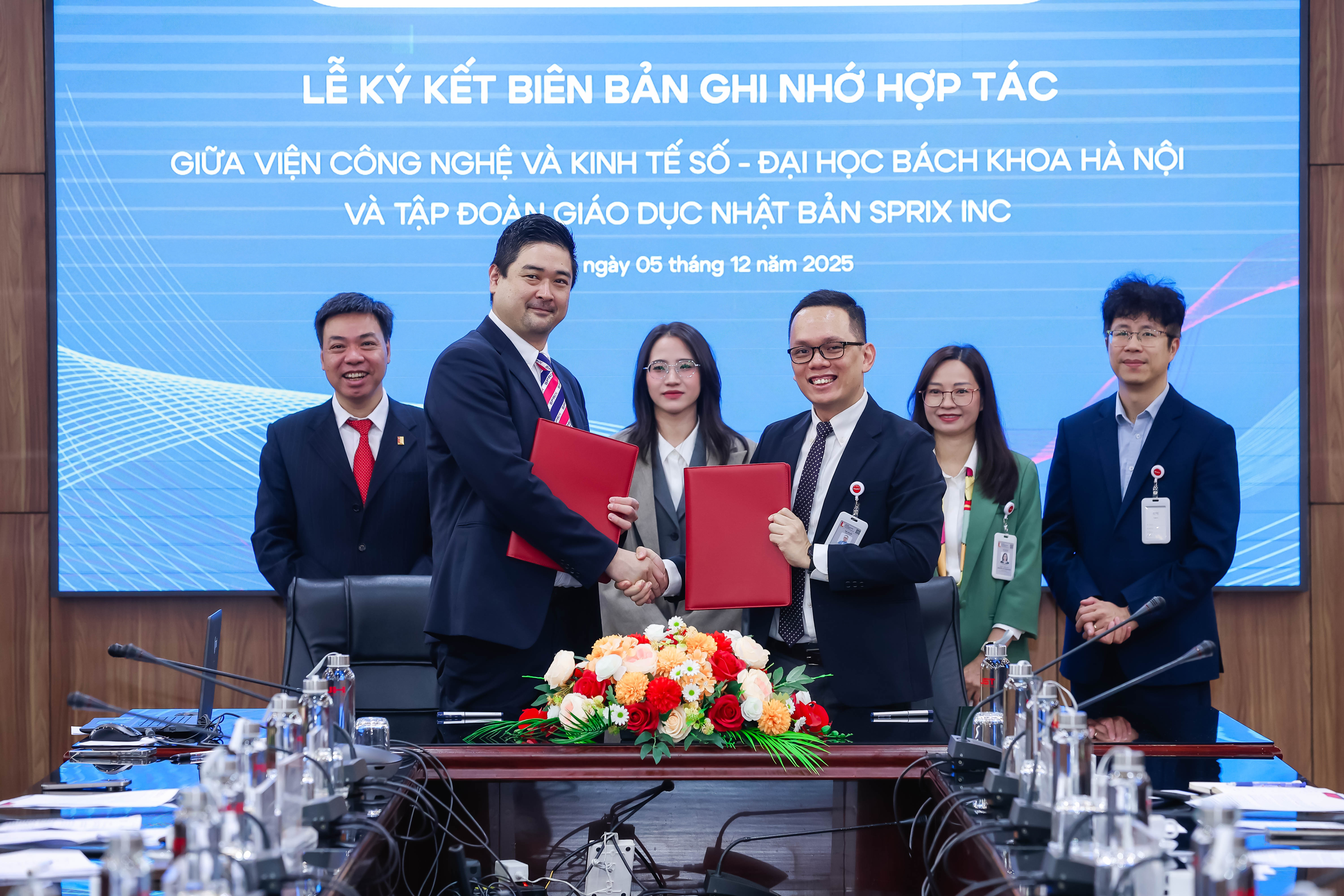 Assoc. Prof. Nguyen Binh Minh, Dean of the Institute for Digital Technology and Economy, HUST, and Mr. Yusuke Homma, Representative of the SPRIX Inc., exchange MoU